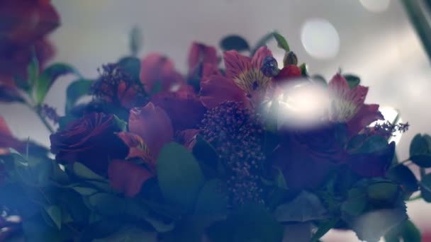 Through the show-window of a flower shop, you can see many different flowers and bouquets. — Stockvideo