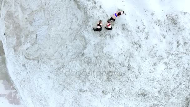 Three young, athletic women doing stretching exercises, warm-up, on the sandy top of the quarry, on the beach. dawn. Aero video shooting. view from above. — Stock Video