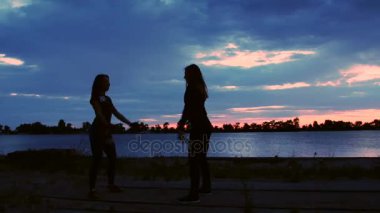 Güzel, ince genç kadın fitness içinde nişanlandık, güç egzersizleri gerçekleştirin. Şafakta güneşin karşı çekim video kargo bağlantı noktası, kum iskele boyunca. Güneş doğarken,