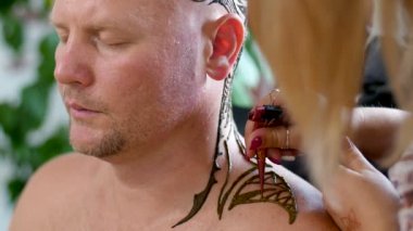 Bir close-up çizim, süsleme, kına dövme, kafa derisi, omuz, boyun. Ciltte kına kurur çözüm. Kına bir tüp cilt için başvuru süreci.