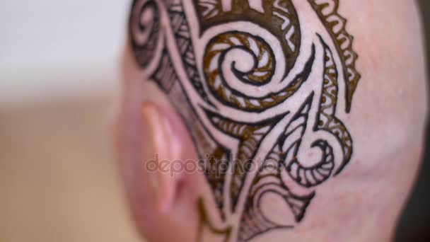 Um close-up do desenho, ornamento, tatuagem de hena, no couro cabeludo, ombro, pescoço. A solução de henna seca na pele. O processo de aplicação de henna de um tubo para a pele . — Vídeo de Stock