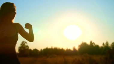 Şekil, uzun sarı saçlar, güzel, atletik bir kızla taslağını egzersizleri, boks gün batımında, mavi gökyüzü güneş ışığı altında yaz aylarında, mu.