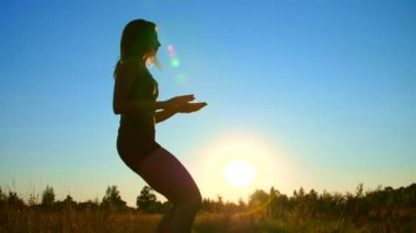 Boks, bacaklar, günbatımında güneş ışığı altında mavi gökyüzü yaz aylarında atlama uçan egzersizleri, şekil, uzun sarı saçlar, güzel, atletik bir kızla taslağını mu.