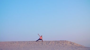 Sağlıklı, genç güzel kadın meditasyon, germe, pratik yoga deniz plajda güneş doğarken, denge ve koordinasyon, derin Kas tonusu için egzersizler yapar.