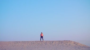 Sağlıklı, genç güzel kadın meditasyon, germe, pratik yoga deniz plajda güneş doğarken, denge ve koordinasyon, derin Kas tonusu için egzersizler yapar.