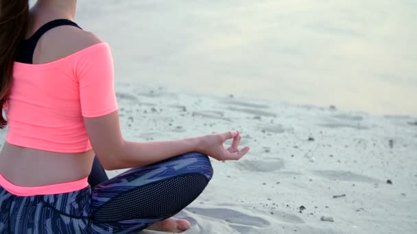 Donna seduta in posa rilassante yoga sulla spiaggia del mare. Primo piano — Video Stock