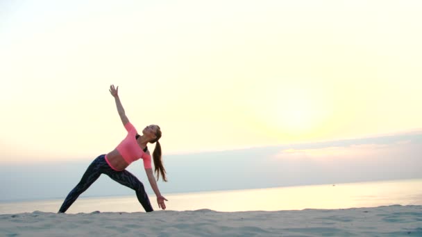 Meditasyon, sağlıklı, genç güzel kadın deniz plaj, gündoğumu, denge ve koordinasyon, derin Kas tonusu yapar tatbikatların pratik yoga. yakın çekim — Stok video