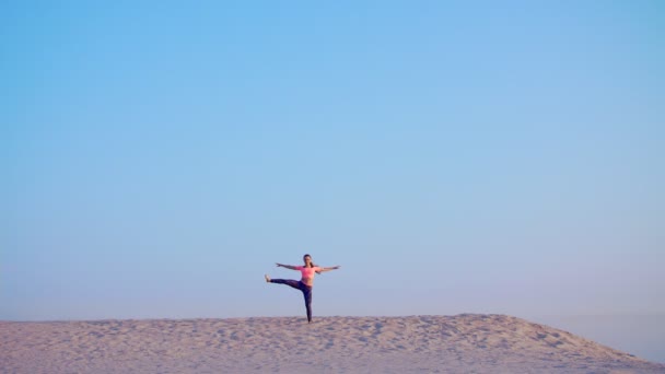 Donna sana, giovane e bella che medita, si allunga, pratica yoga sulla spiaggia di mare, all'alba, Fa esercizi per l'equilibrio e la coordinazione, tono muscolare profondo . — Video Stock