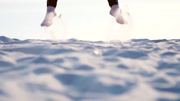 Gros plan, sur le sable sautant pieds d'athlétisme féminin, à la lumière du soleil. Sur la plage, en été, au lever du soleil — Video