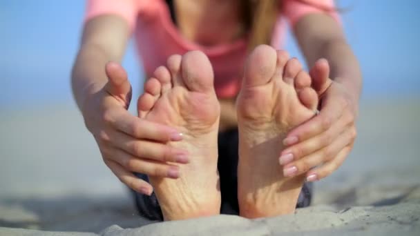 Piękne blond kobieta robi, stretching ćwiczenia na plaży. Zbliżenie stóp — Wideo stockowe