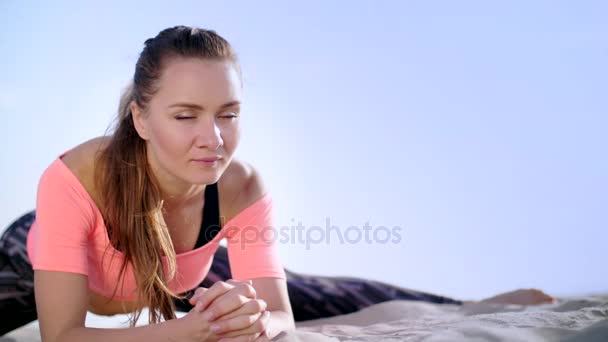 Gezonde, jonge mooie vrouw uitrekken, praktizerende yoga op het strand, bij zonsopgang, maakt oefeningen voor de balans en coördinatie, diepe spiertonus. ontspanning van de spieren, erg — Stockvideo