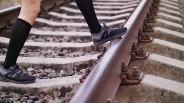 Yakın çekim, yaz aylarında demiryolu Ray üzerinde siyah spor ayakkabı ve tozluk kadın atletik bacaklarda atlamak. erkek egzersizleri bacaklar için gerçekleştirir.,