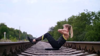 Güçlü basın, karın kasları yapmak için güzel seksi atletik genç sarışın kadın siyah tozluk çalışmaları gerçekleştirme. Uyuyanlar, demiryolu, yaz aylarında Slowmotion oturur