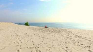 Sağlıklı, genç güzel kadın meditasyon güneş gözlüğü, germe, pratik yoga deniz plajda güneş doğarken, denge, koordinasyon, derin kas tonu egzersizleri yapar.