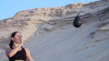 atletik kız siyah top bir uygulama başladı, ayakları balon, renkli su önünde başladı. Kız ayağıyla balon başladı ve ıssız bir sahilde su sızıntıları--dan o, yaz,