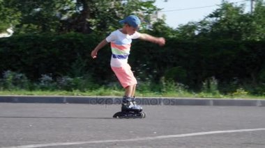 Yedi, paten, sıcak bir yaz günü mutlu bir çocuk. Ağır çekim