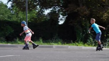 Mutlu çocuk, yedi, paten, sıcak bir yaz günü, iki erkek. Ağır çekim