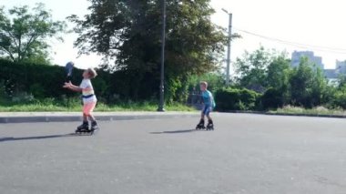 Mutlu çocuk, yedi, paten, sıcak bir yaz günü, iki erkek. Ağır çekim