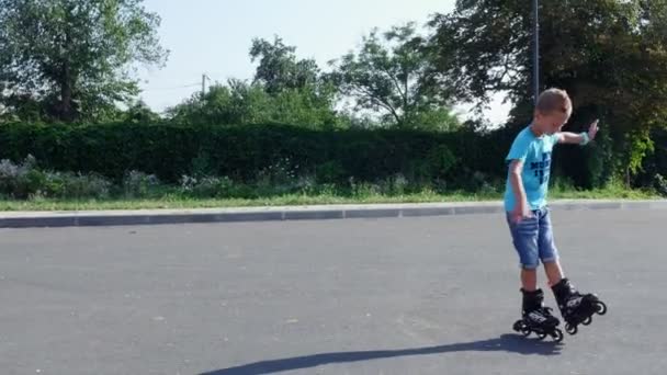 Niños felices, dos chicos de siete años, patinando, un caluroso día de verano. Movimiento lento — Vídeo de stock