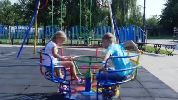 Šťastné děti, děvče a chlapec sedmi, jezdit na houpačce, v horkém letním dni. Zpomalený pohyb. Veselá šťastné dětství, dovolená. — Stock video