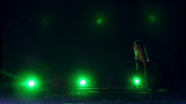 Atletisk, vacker, ung kvinna göra olika styrkeövningar med vikter. På natten, mot bakgrund av multi-färgade strålkastare, i ljus rök, dimma, i en gammal övergiven hangar, — Stockvideo