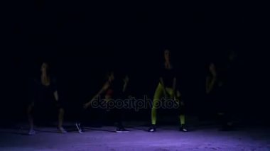 Dört atletik kadın, gece, terk edilmiş eski bir hangarda bir stobascope ışığında hafif duman, sis ile ağırlıkları, Fitness egzersizleri yapıyor, Bina