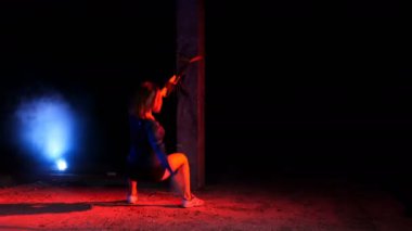 atletik, seksi bir kadın fitness trx sistemi, Trx askı kayışları ile çalışmaları gerçekleştirir. Gece, çok renkli projektörler, ışığında hafif duman, sis içinde binayı terk