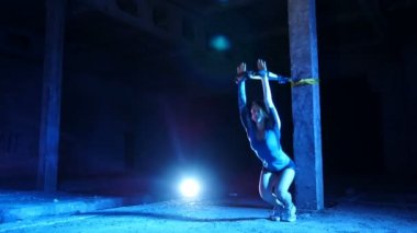 atletik, seksi bir kadın fitness trx sistemi, Trx askı kayışları ile çalışmaları gerçekleştirir. Gece, çok renkli projektörler, ışığında hafif duman, sis içinde binayı terk