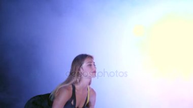 atletik, güzel, seksi bir kadın ile Halter egzersiz, bu yükseltir. Geceleri hafif duman, sis, çok renkli projektörler ışığında içinde binayı terk edilmiş bir.