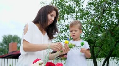 Summer, Bahçe, ağır çekimde anne dört yaşındaki oğlu olan süslemeleri meyve suyu için bardağı taşıran damla. Bu çok fazla, o sevinir, eğlenceli, çocuk seviyor dilini gösterir.