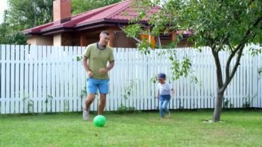 Top, futbol, yaz aylarında yeşil çim bahçesinde oynayan 4 yaşındaki oğlu olan baba.