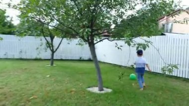 Top, futbol, yaz aylarında yeşil çim bahçesinde oynayan 4 yaşındaki oğlu olan baba.