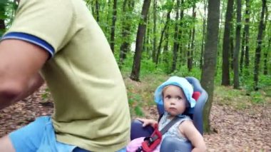 Yaz aylarında, orman, bir bisiklet sürme bir çocukla bir adam çocuk özel bir sandalyede oturuyor
