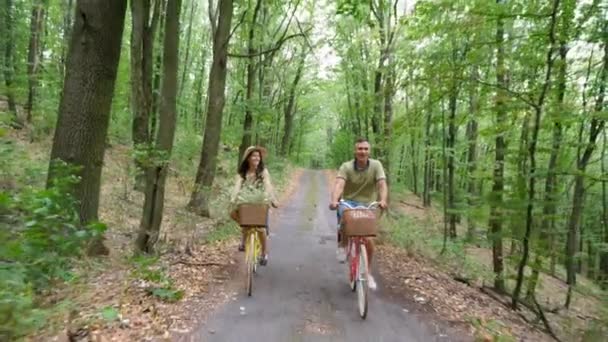 Francia család, apa, anya egy kalapot és ruhát, és egy kosár virágot, valamint a kis gyermekek, lovagolni kerékpárok, az erdő, a nyár. — Stock videók