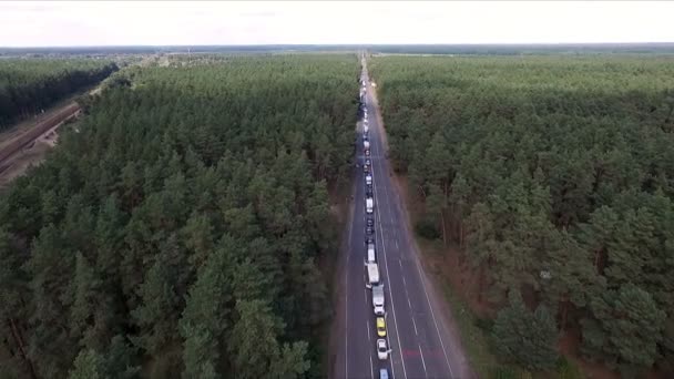Aero nahrávání videa. Léto, dne, krajiny, uprostřed lesa je silnice. Na cestě je mnoho aut, v linii, dopravní zácpy. — Stock video
