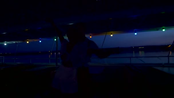 ディスコ。夜、飾られたカラフルなライト、若者ダンス、抱擁、その概要、数字、抱擁、キス、フェリーの甲板で. — ストック動画