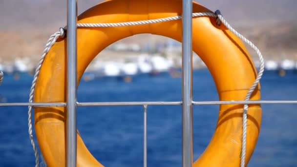 Verano, mar, boya de vida naranja, colgando a bordo de un ferry, barco. equipo especial de rescate de la nave. salva la vida de una persona que se está ahogando . — Vídeo de stock