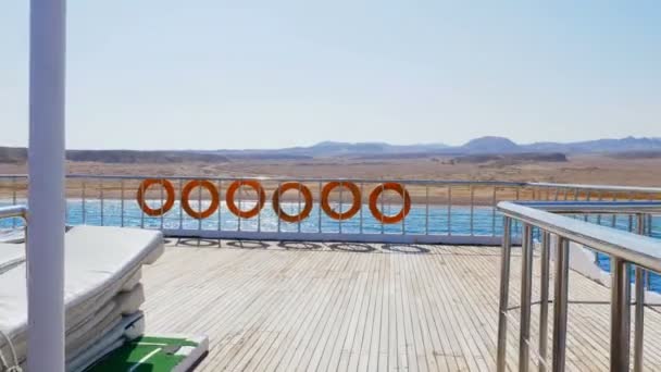 Verano, mar, vuelo de una cámara de vídeo a lo largo de la cubierta del ferry, barco, a bordo cuelga muchas boyas salvavidas de color naranja — Vídeos de Stock