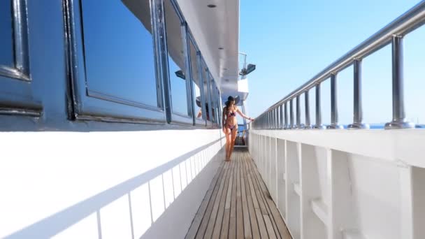 Verano, mar, hermosa mujer morena joven sexy con un traje de baño, sombrero de sol y gafas de sol, caminando por la cubierta del ferry, barco, disfrutando del resto, la belleza del mar, feliz, sonriente . — Vídeo de stock