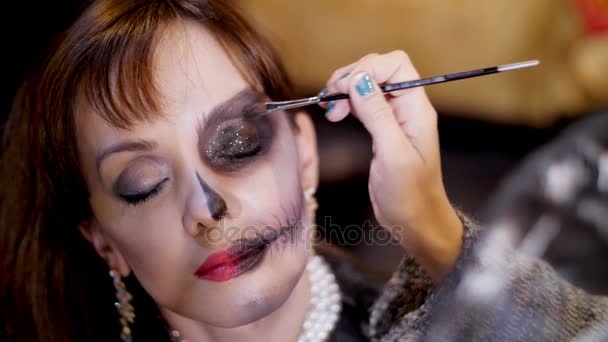 Halloween party, великим планом, візажистом звертає страшні макіяж на обличчі брюнетка жінка для Halloween party. декорації в стилі Хеллоуїн розглядається — стокове відео