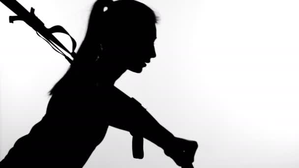 Auf weißem Hintergrund, Schatten, schwarzer Umriss einer weiblichen Figur, die Übungen mit dem Fitness-Trx-System macht, Trx-Aufhängeriemen. — Stockvideo