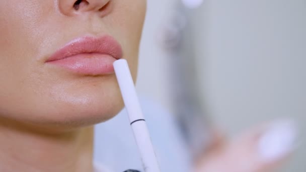 Clínica, um salão de beleza, um grande plano dos lábios, o médico mostra ao paciente uma zona labial para injeção de ácido hialurônico, discutir o procedimento de aumento labial — Vídeo de Stock