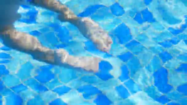 In the pool, the children flop down in the water, the suns rays are reflected in the waves of water, — Stock Video