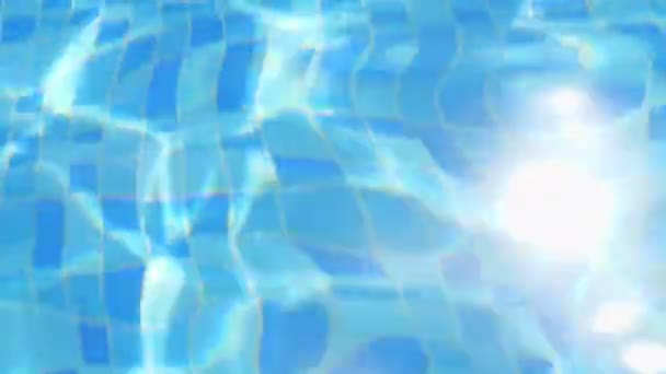 dans la piscine, les rayons du soleil se reflètent dans les vagues d'eau, gros plan 