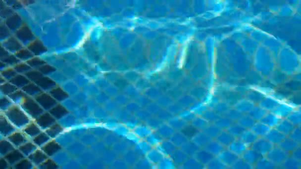 In het zwembad, de stralen van de zon worden doorgevoerd in de golven van water, close-up — Stockvideo