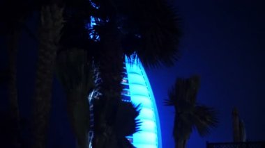 Dubai, Birleşik Arap Emirlikleri, BAE - 20 Kasım 2017: Otel Jumeirah. Taksi-böcek, parlayan Burj al palmiye ağaçları titreşen Arap, otel-yelken, geçirerek tarafından gece yürüyüş