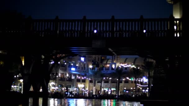 DUBAI, EMIRATOS ÁRABES UNIDOS, Emiratos Árabes Unidos - 20 de noviembre de 2017: Hotel Jumeirah Al Qasr Madinat, paseo nocturno por el canal de agua, en barco. el barco nada bajo el puente . — Vídeos de Stock