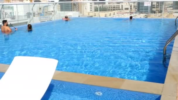 DUBAI, EMIRATI ARABI UNITI, Emirati Arabi Uniti - 20 NOVEMBRE 2017: Vista dalla piscina sul tetto della città. persone che si rilassano in piscina con vista sui grattacieli, centro commerciale degli Emirati — Video Stock