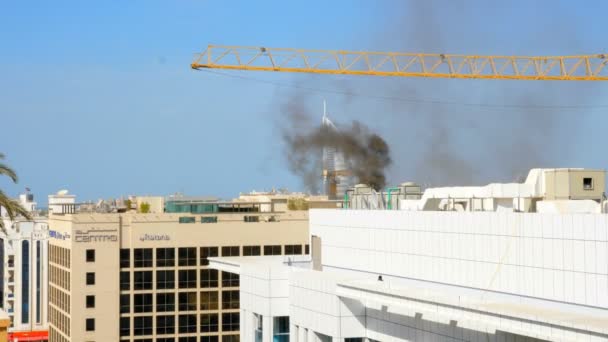 20 ноября 2017 года в Дубае произошел пожар в здании напротив отеля Jumeirah Burj al Arab. Черные облака дыма поднимаются в небе, парусный отель все в — стоковое видео