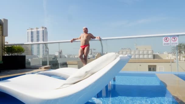 Kaukasischer Geschäftsmann entspannen im Luxus-Swimmingpool auf dem Dach mit wunderschönem Stadtblick auf Wolkenkratzer — Stockvideo